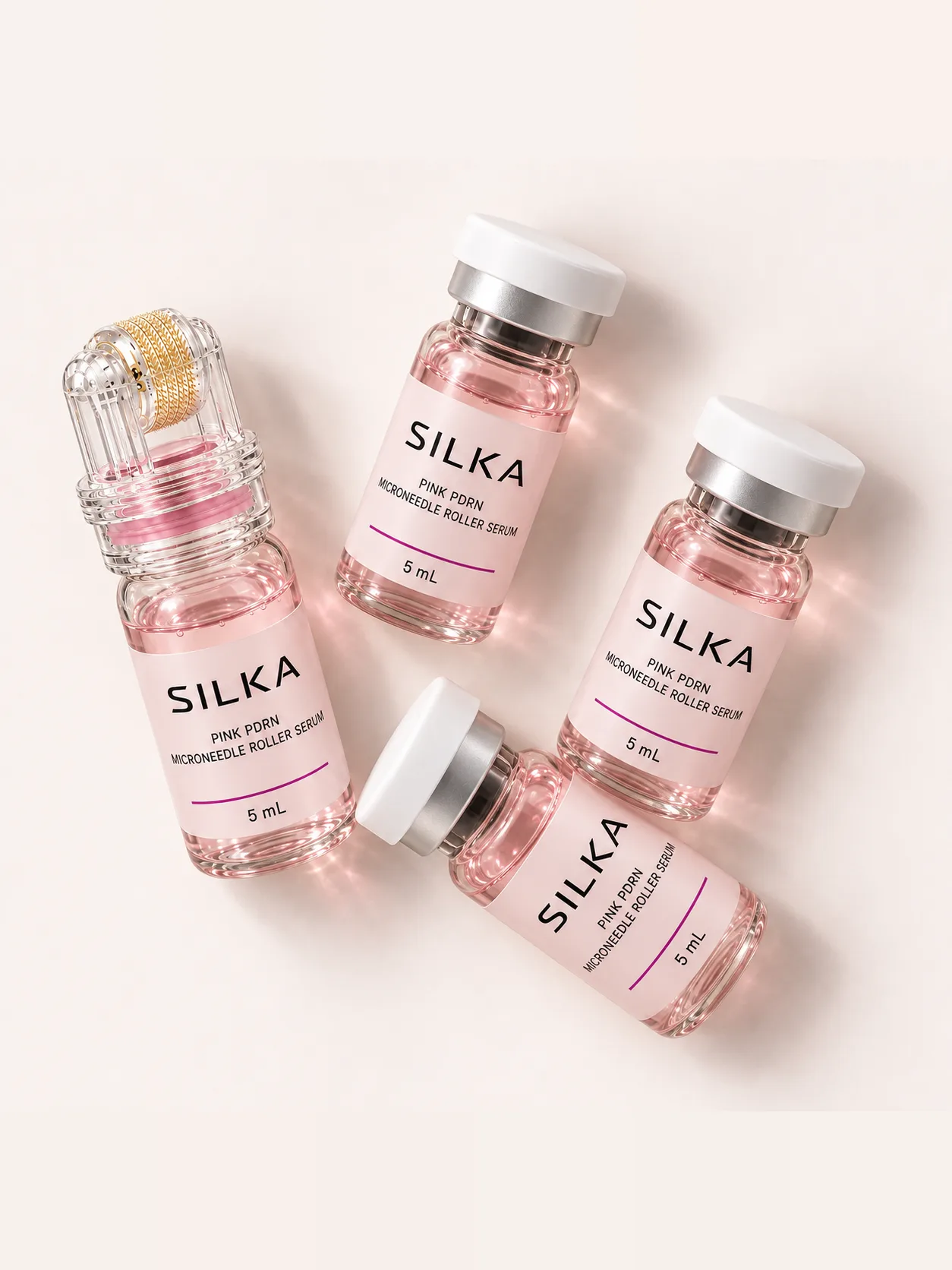 The roller and three sealed ampoules laid out on a pale pink ground